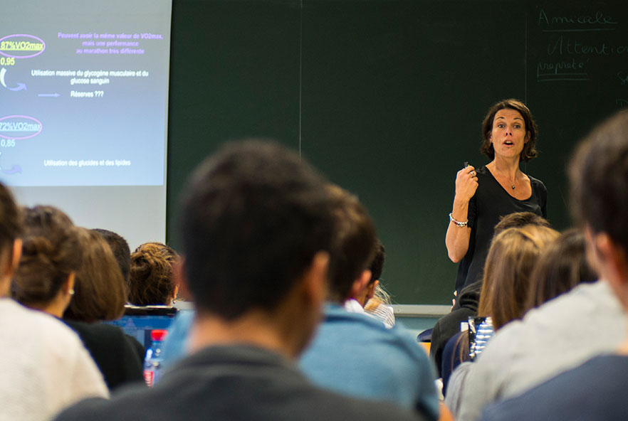 A teacher stands at the front of a class