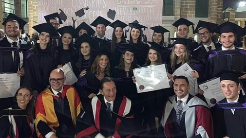 Graduates and educators in caps and gowns and holding certificates