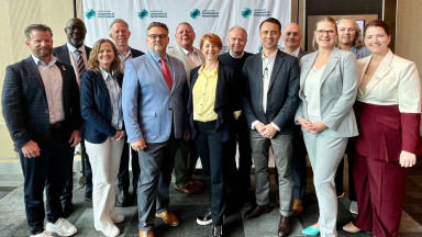 A group of professionals standing proudly in a line during the Founders' Meeting