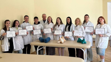 A group of physiotherapists standing in a classroom holding certificates